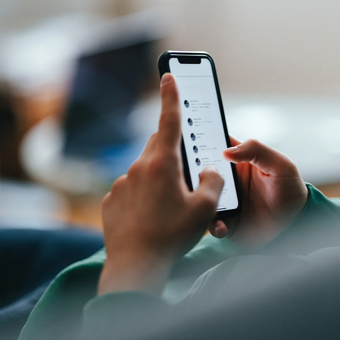 Persona che utilizza uno smartphone con una mano mentre scorre lo schermo con l’altra.